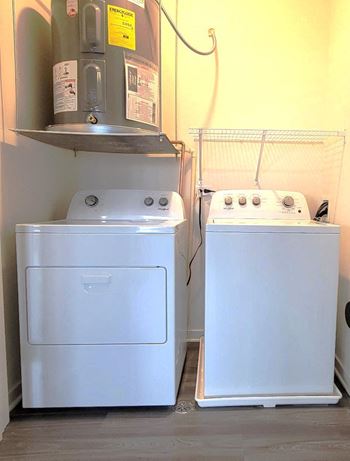 Two washers and a dryer in a small room